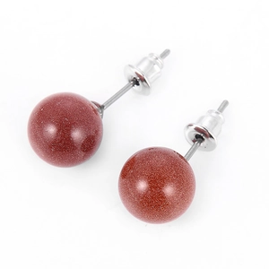 Macro detail of 10mm round goldstone earrings with silver-plated studs on white surface