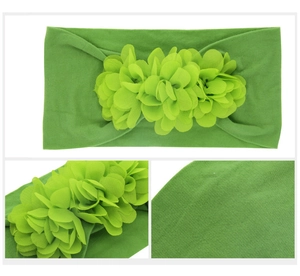 Macro detail of green nylon baby headband featuring three soft chiffon flowers