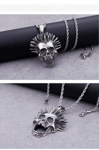 Detail of silver punk skull pendant with metallic spikes and stainless steel twisted chain