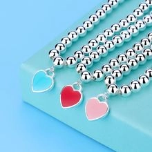 Close-up of beaded bracelets with colorful heart charms on a premium blue display box