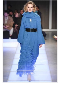 Close-up of a wide black elastic corset belt styled on a blue knitted tassel dress