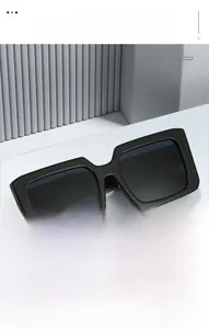 Detailed view of black square sunglasses with thick temples on a modern pedestal