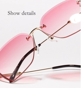 Detail shot of golden metal bridge and soft pink gradient lenses on rimless sunglasses