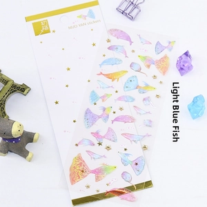 Close-up of translucent gold-stamped dolphin stickers with colorful glitter finish