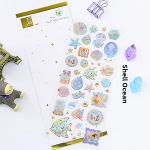 Detailed view of ocean-themed stickers with gold foil, featuring shells and marine life