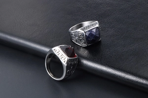 Macro shot of silver titanium rings with blue sunstone and garnet on black leather