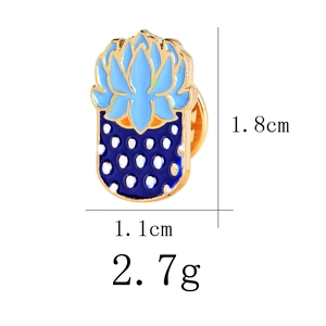 Blue enamel pineapple pin detail with size measurements 1.8cm by 1.1cm on white background