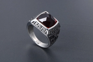 Macro detail of men's retro ring featuring red square gemstone and Greek key patterns