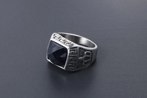 Detailed macro view of men's steel ring with blue sandstone and Greek key relief