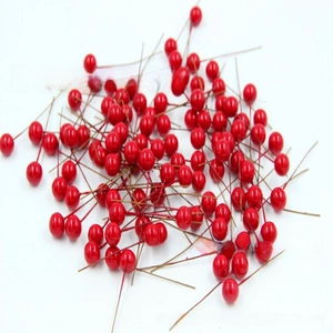 Close-up of shiny red artificial berries with wire stems for DIY floral crafts