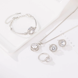 Detailed view of silver jewelry set with halo-set round brilliant zircons and sparkling accents