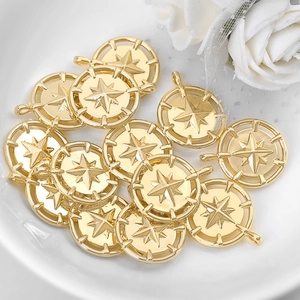 Golden round compass star metal pendants for DIY jewelry making displayed on a white plate