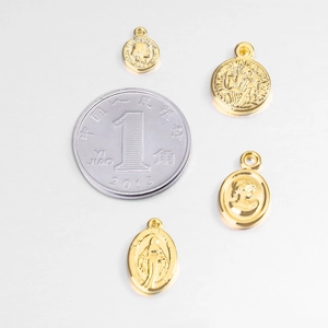 Gold coin metal pendants with embossed motifs shown with size reference coin