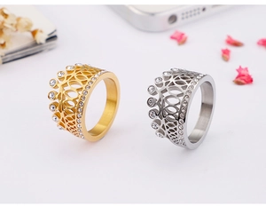 Detailed close-up of crown-shaped titanium rings in gold and silver with zircon inlays