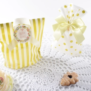 Yellow striped and gold polka dot cookie gift bags with ribbons for holiday treats