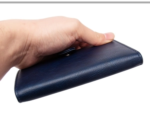 Detailed macro view of dark blue litchi pattern PU leather passport holder with snap button