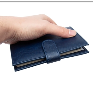 Close-up of navy blue pebbled leather passport holder with secure buckle closure