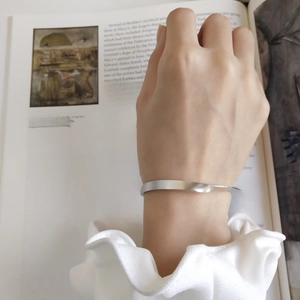 Bracciale rigido aperto in argento S925 con finitura spazzolata opaca e design ritorto