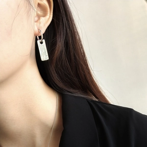 Detailed close-up of vintage 925 sterling silver square tag earrings on a model's ear