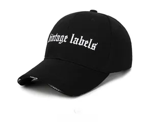 Detail view of black cotton baseball cap with white Vintage labels gothic embroidery