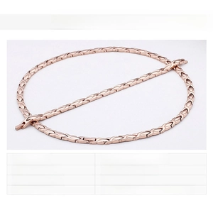 Detail view of rose gold magnetic therapy bracelet and necklace with X-link pattern