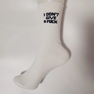 Detailed macro view of white ribbed cotton socks featuring bold black letter embroidery