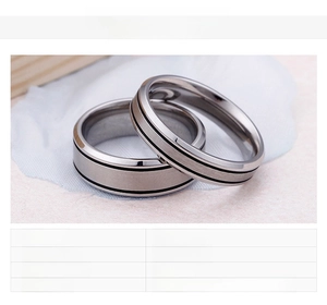 Macro shot of stainless steel couple rings with matte finish and black stripe detail
