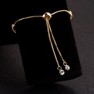 Adjustable golden cubic zirconia bracelet with heart pendant on black velvet display