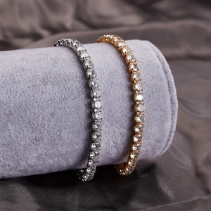 Detailed close-up of gold and silver tennis bracelets with cubic zirconia on silk cloth