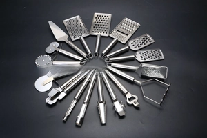 Flat lay macro of 14-piece stainless steel kitchen tool set on black background