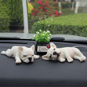 Two sleeping French Bulldog figurines on a car dashboard, cream resin dog car decoration
