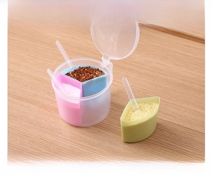 Detail view of 3-compartment spice box with individual spoons on wooden background