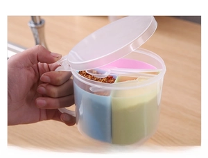 Detail of multi-compartment seasoning box with transparent lid and colorful inner dividers
