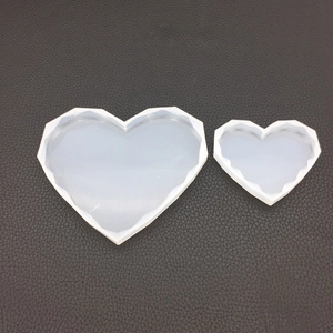 Macro view of heart-shaped silicone molds with geometric diamond faceted edges for DIY resin art