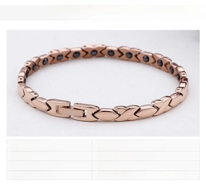 Detail of rose gold stainless steel bracelet with X-shaped links and black magnetic stones