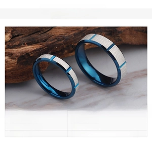 Detail view of silver brushed stainless steel rings with blue inner grooves and specs