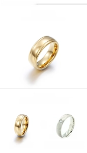 Close-up of polished tungsten steel rings with grooved gold finish and silver inlay