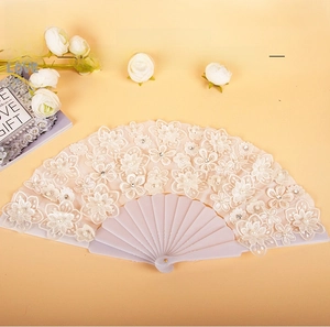 Detail of white lace folding fan with floral embroidery, pearls, and sequins