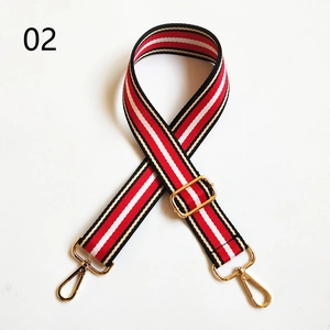 Detail of adjustable wide shoulder strap with red white and black stripes and gold hooks