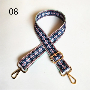 Close-up of adjustable ethnic geometric woven canvas strap with gold metal hooks