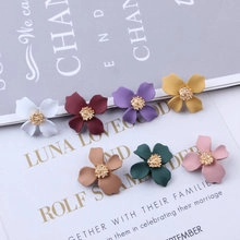 Flat lay of colorful matte flower pendants with golden centers for DIY jewelry making