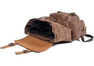 Detail of vintage waxed canvas backpack with leather straps and drawstring closure