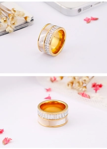 Detail view of gold shell ring with square cut zircons on a white background with petals