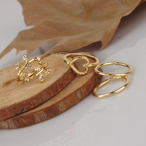 Golden 4-piece ring set featuring leaf rhinestone, heart design on wood block