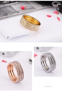 Close-up of triple-row stainless steel rings in gold, rose gold and silver with zircon