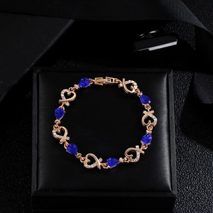 Rose gold heart bracelet with blue teardrop stones and zircon inlay on black velvet