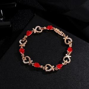 Elegant rose gold heart bracelet featuring red teardrop gems and sparkling crystals