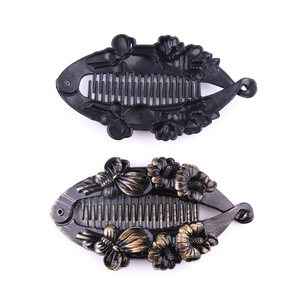 Detail of banana hair clips with floral and butterfly patterns in black and bronze