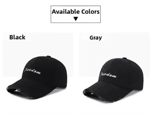 Detail of gray and black baseball caps with white Freedom cursive embroidery on front
