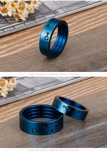 Close-up of blue plated stainless steel couple rings with male and female symbols